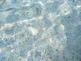 The sea water is clear and clear, and the sand is shining from the sun reflected on the water surface.