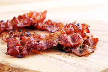 Closeup of slices of crispy hot freshly cooked bacon for tasty breakfast