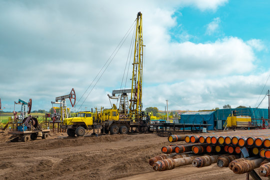 Workover rig working on a previously drilled well trying to restore production through repair. The pumping units and well workover operation
