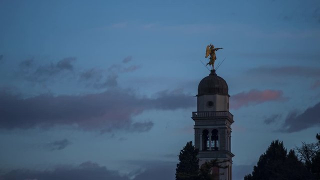 Timelapse at sunset with the bell tower with angel statue at Castle of Udine