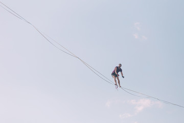 Highliner on the background of blue sky.