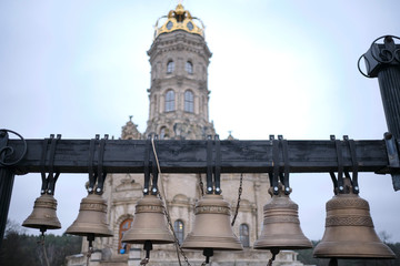 Fototapeta premium Bronze bells against the background of the church tower.