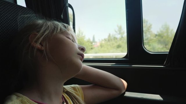Little girl sleeps on car window, tedious ride