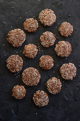 Obraz na płótnie Canvas Vegetarian gluten free food. Homemade chocolate cookies with sesame seeds on black background