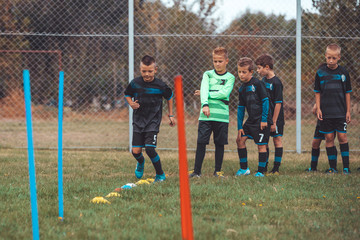 Young Boy of School Junior Soccer Team Practicing on Grass Field