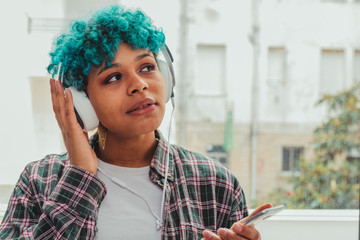 girl or woman with mobile phone and headphones at home