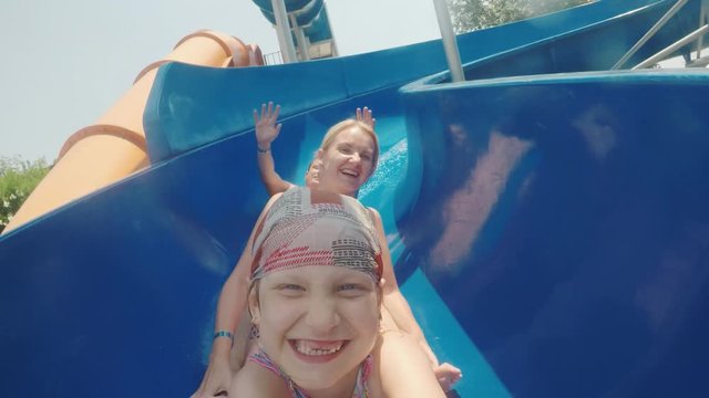 Funny family with a child comes down from the water slides