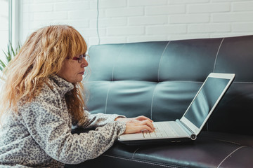 adult woman with laptop on the sofa at home