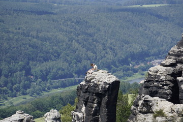 Man and womand sitting on a sandstone rock in the Schrammstein region