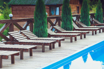 Wooden deck chairs for relaxing by the pool