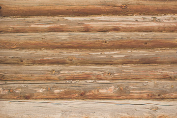 A wall of logs. Background of light brown wooden logs. Seamless wood texture from logs.