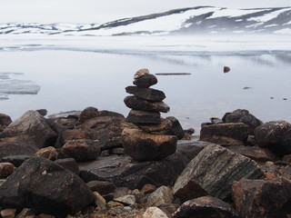 Stone piramid is on the background of white snowing mountains