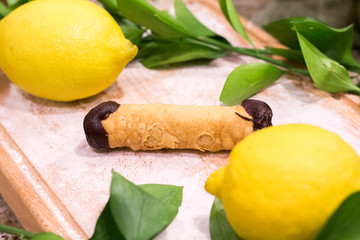 Italian cannoli with lemons and orange tree leaves surrounding