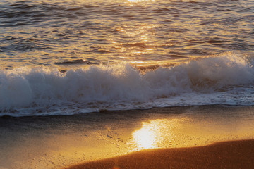 Golden sunset on the beach. Sea waves in the sunset on the ocean