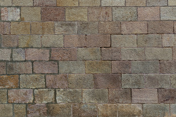Brick wall background. Old brickwork with multicolor bricks in tints of pink, yellow, green.