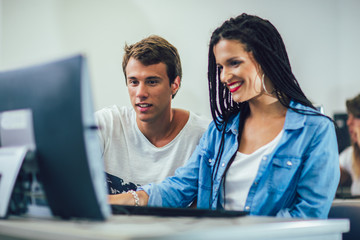 College students sitting in a classroom, using computers during class.