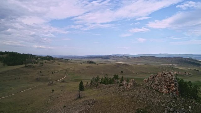 Baikal Valley spirits,Tazheran steppe, stone cliffs on the road. Aerial Summer