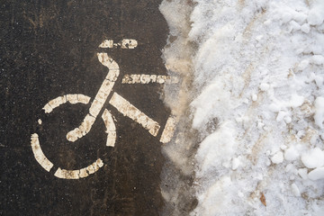Bicycle path in winter under the snow. The bike season is closed due to ice. Biking in cold...