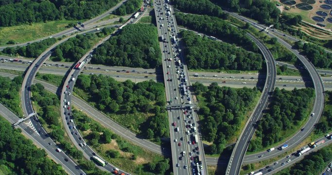 Aerial view of traffic over a major highway interchange, full of cars and trucks. Shot on Red Weapon 8K.