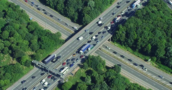 Aerial view of traffic over a major highway interchange, full of cars and trucks. Shot on Red Weapon 8K.