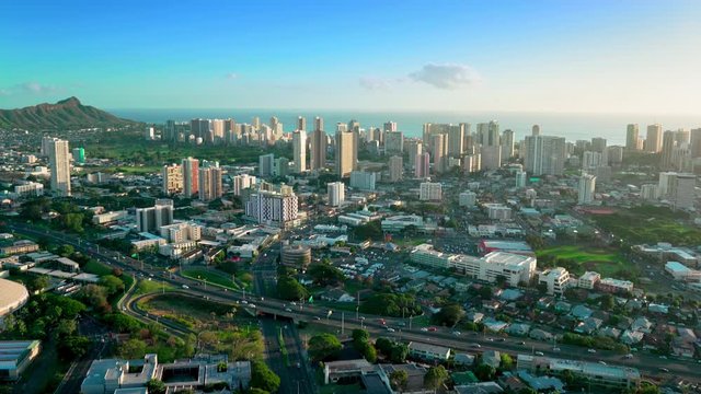 Aerial view of the H1 highway full of traffic. Residential neighborhood with huge homes. Diamond Head Crater with Honolulu skyline in the background. Oahu island. Hawaii. Unites States.