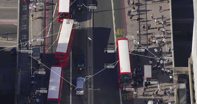 Surveillance concept. Aerial view of commuters walking near London Bridge. Facial recognition interface showing personal data for each person.  Artificial intelligence. Shot on Red Weapon 8K.