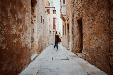 Fototapeta na wymiar .Pretty young girl traveling around the island of Malta. Knowing its culture and visiting the old capital, Mdina, known as the Silent City. Relaxed and carefree. Travel photography. Lifestyle..