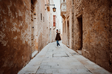 Fototapeta na wymiar .Pretty young girl traveling around the island of Malta. Knowing its culture and visiting the old capital, Mdina, known as the Silent City. Relaxed and carefree. Travel photography. Lifestyle..