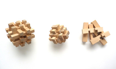 Line of Burr Puzzles | Interlocking Puzzles | Three-Dimensional Wooden Puzzles on a White Background | Wooden Puzzles Being Built