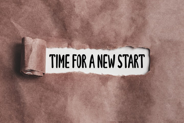 time for a new start text on torn paper
