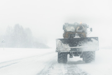 Naklejka premium Tractor is removing a snow from a road. Road service.