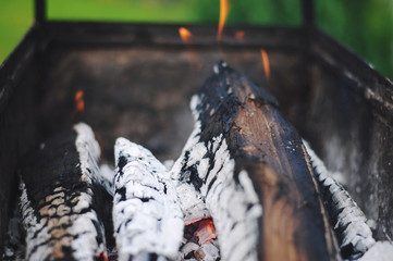Wood burning and fire in the portable metal grill, fireplace. Fire and charcoal grilled, preparation for barbecue