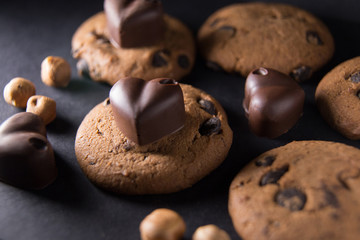 Symbol of lovers chocolate hearts lie on cookies next to nuts scattered