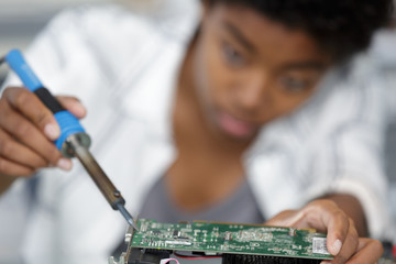 female engineer fixing broken computer hard drive
