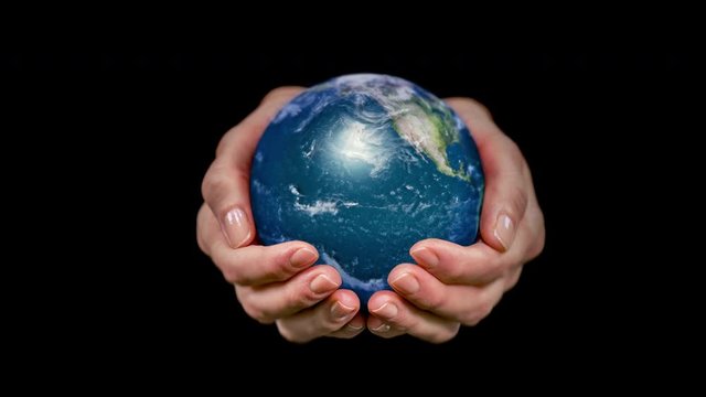 Female hands holding a rotating hyperrealistic Earth over black background. 