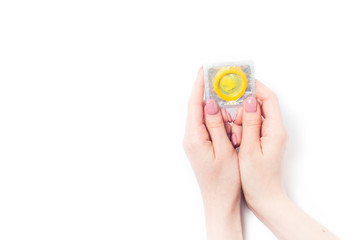 color condom in female hand isolated on a white background