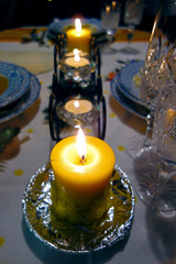 Christmas candle burning on festive table setting