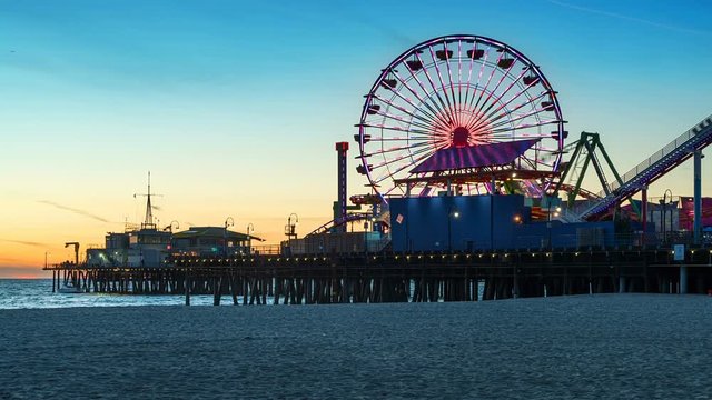 Santa Monica Pier at sunset. Beautiful beach in Los Angeles, California, United States. Timelapse. Colorful Amusement Park in the coast. 