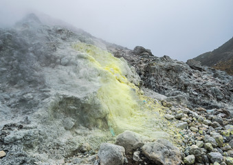 Steaming fumarole covered in sulphur deposits at a slope of Mount Sibayak stratovolcano in Sumatra, Indonesia.