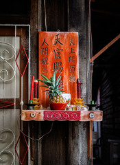 Lucky pineapple placed at a small family altar at the Chinese clan jetties area in Penang.