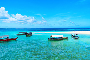 Panoramic view of a beautiful sunny day on sandy beach and fishing boats in the Zanzibar.