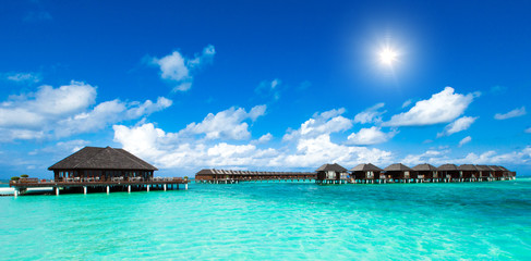 Beach with white sand, turquoise ocean water and blue sky with clouds in sunny day. Natural background for summer vacation. Panoramic view.
