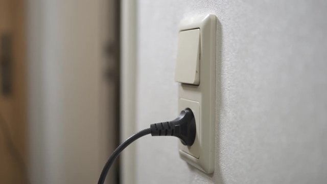 Stecker in eine Steckdose einstecken 