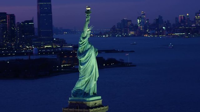 Aerial view of the Statue of Liberty at dusk. Manhattan and New Jersey skyline. New York City, United States. Shot from helicopter.