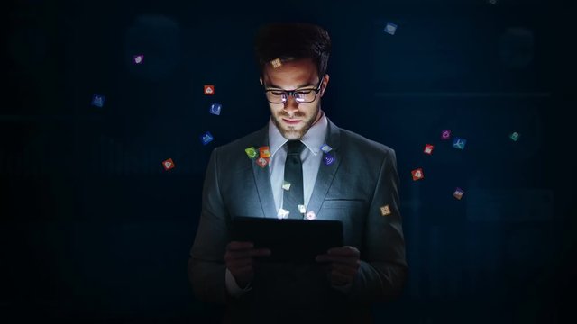 Businessman using a tablet with holographic icons. VR. Futuristic technology. Augmented reality. Multicolored.