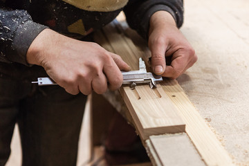 The joiner measures products. Joiner measuring tool at work.