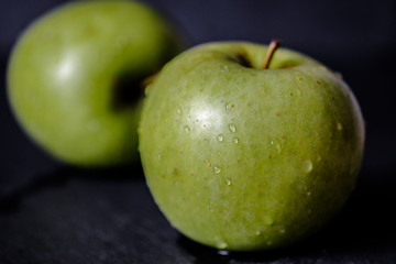 Green apple, fresh and wet isolated on black background