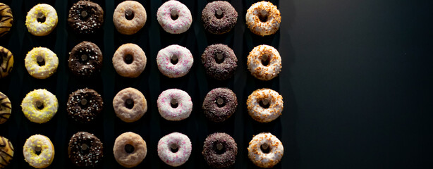 abstract black background of colored donuts, sweet dessert 