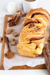 Cinnamon babka or swirl brioche bread. Cinnamon roll bread. Povitica: traditional Polish sweet bread. Homemade pastry for breakfast. Light grey background.