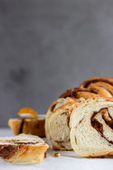 Slices of homemade cinnamon babka or swirl brioche bread. Cinnamon roll bread. Povitica: traditional Polish sweet bread. Light grey background.